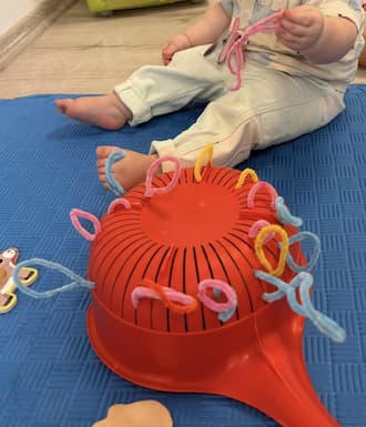 Try this simple toddler activity with pipe cleaner and a colander to boost fine motor skills, hand strength, and focus with almost no prep.