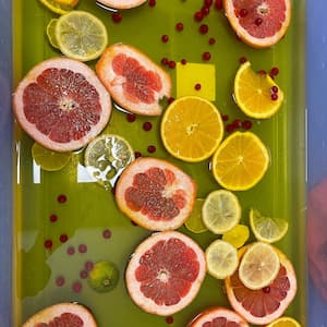 Toddler citrus sensory bin with floating grapefruit, lemon, and orange slices 