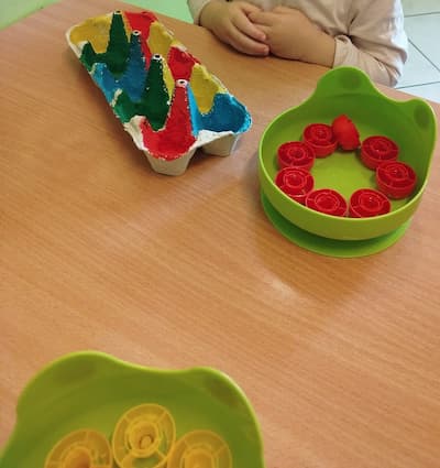 Easy color activities for toddlers using a painted egg carton and smoothie lids