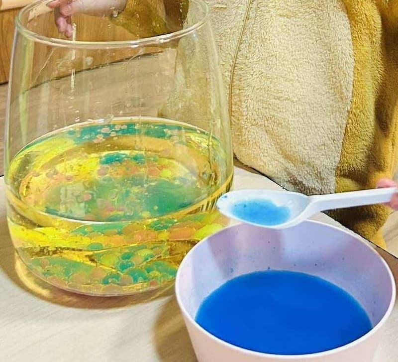 Give your child a spoon or dropper and let them scoop some colored water from the small bowls