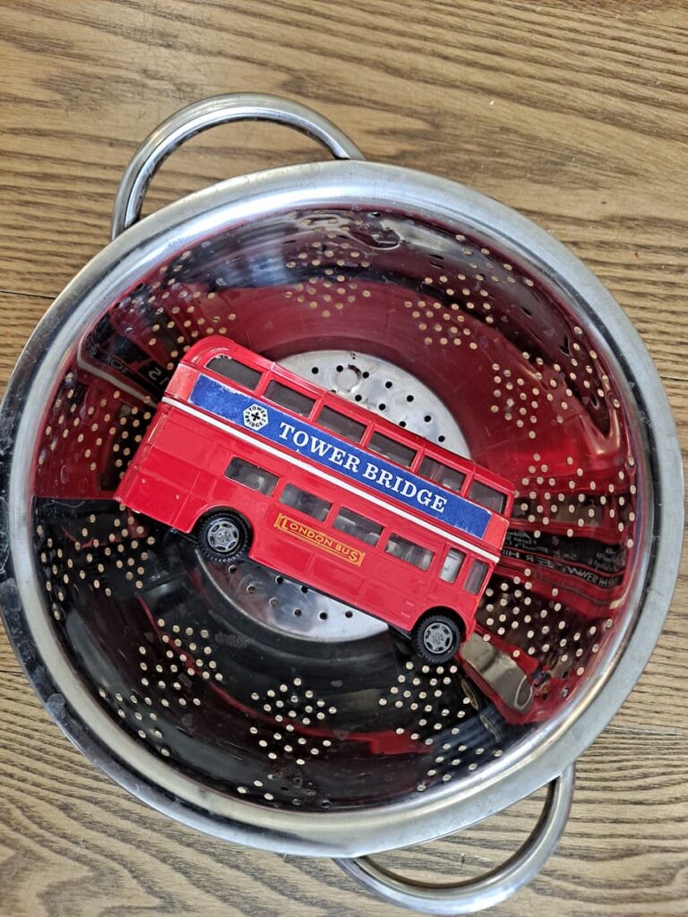 easy fine motor activity for toddlers rescue toy bus stuck in spaghetti colander