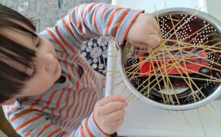 easy fine motor activity for toddlers rescue toy bus stuck in spaghetti colander