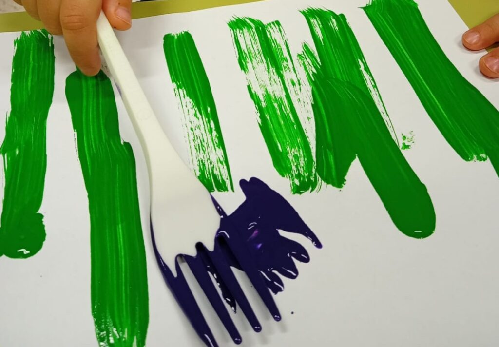 toddler fork painting flowers activity with green stems and colorful paint