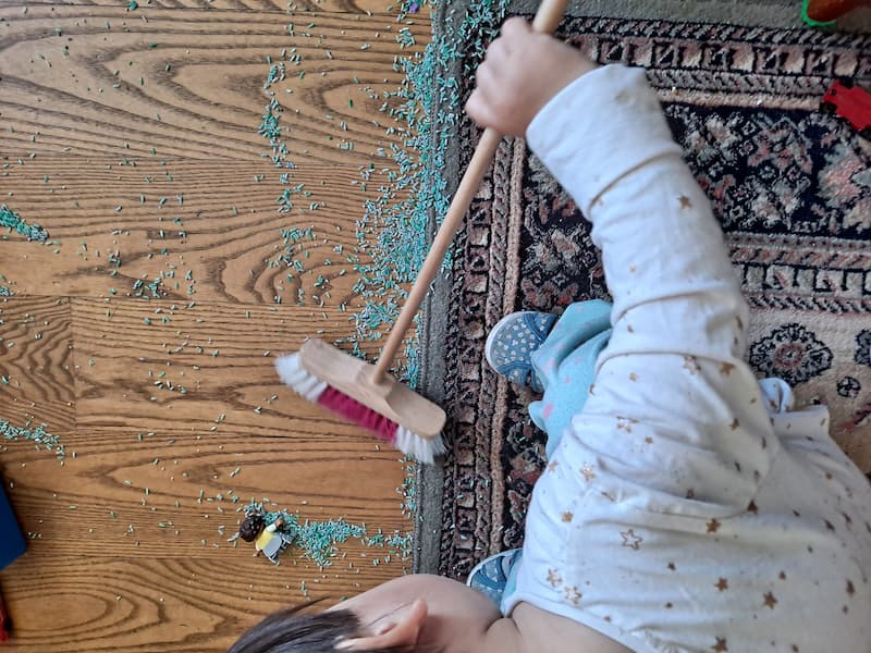 practical life activity toddler sweeping rice